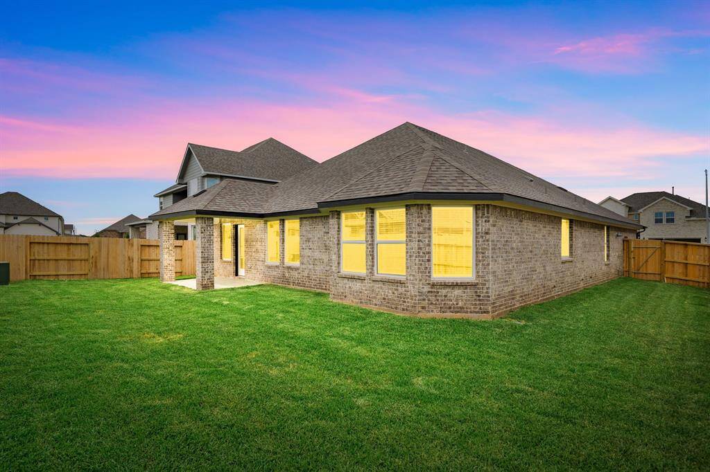 Experience serene evenings in this spacious, fully fenced backyard, beautifully illuminated against a vibrant sunset sky. The well-maintained lawn offers plenty of room for outdoor activities, while the brick exterior and covered patio add charm and functionality. A perfect setting for relaxing or entertaining at dusk.Experience serene evenings in this spacious, fully fenced backyard, beautifully illuminated against a vibrant sunset sky. The well-maintained lawn offers plenty of room for o