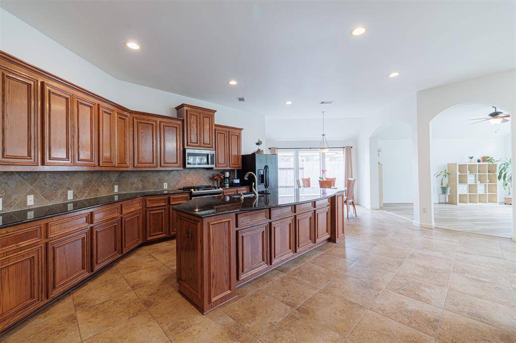 Island kitchen features granite countertops and a breakfast bar.