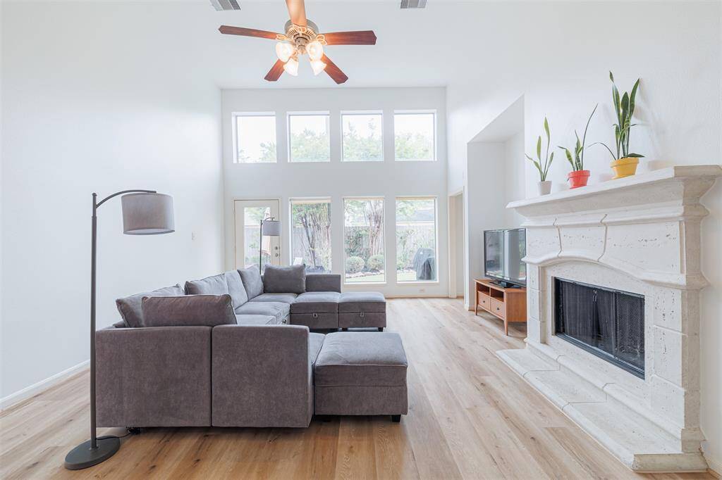 The family room features soaring ceilings, a gas fireplace and wall of windows overlooking the backyard.