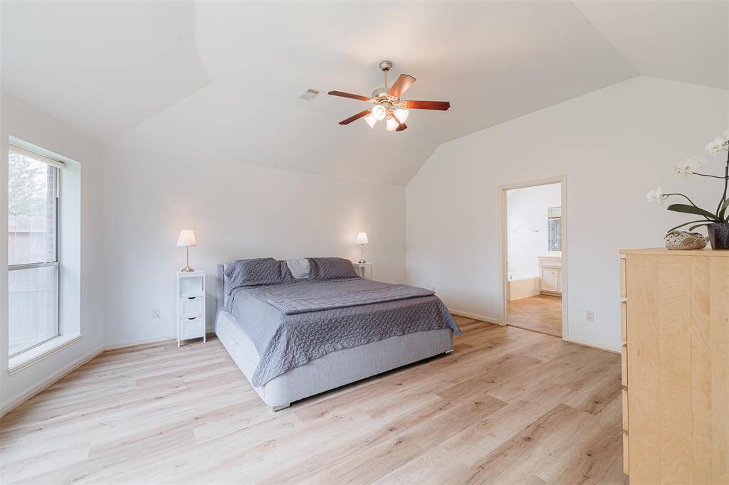 The serene primary suite offers high ceilings and a spa-like bath.