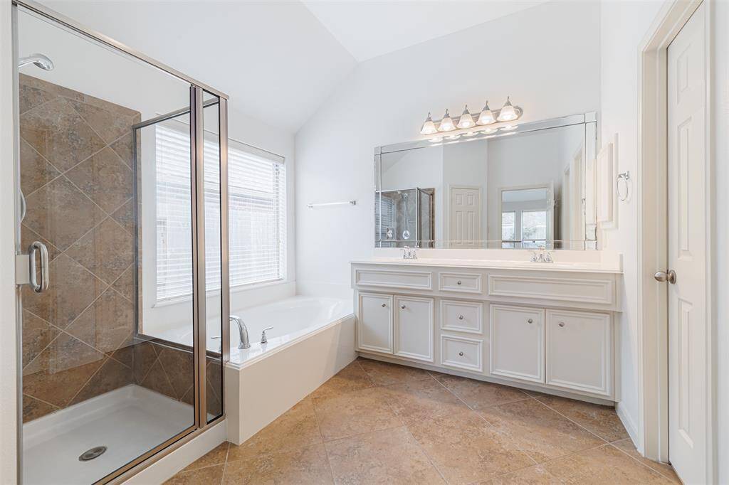 Primary spa-like bath with double sinks, a soaking tub and separate shower and large walk-in closet.