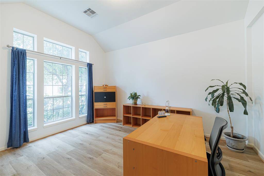 The study features double French doors, high ceilings and luxury vinyl flooring.
