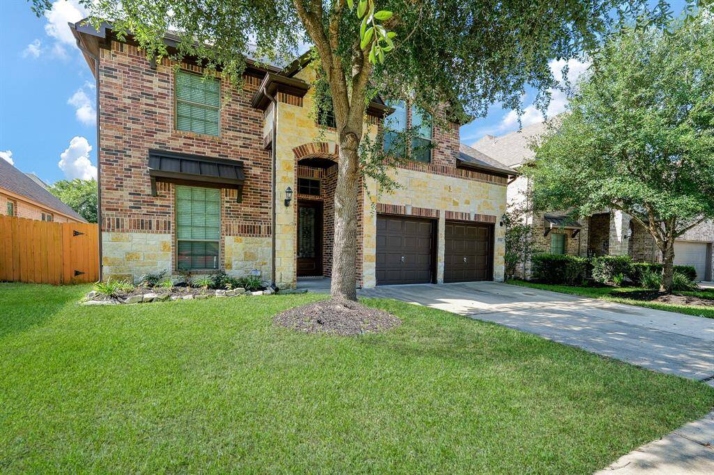 Yes! It is absolutely possible to fall in love with a home at first sight! This gorgeous 2-story brick treasure is located at 27326 Pendleton Trace Drive, Spring, TX, in the highly sought after master planned Harmony Springs community. Impeccably maintained, inside and out, this home's tremendous curb appeal is evident! Shown here is the roomy driveway below attached garages and lovely covered main entrance.