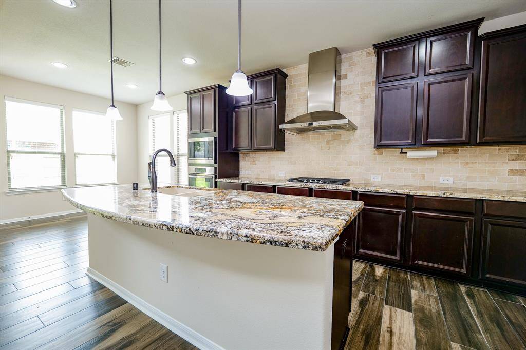 The dynamic visual appeal of dark/light contrasting tones and features in this kitchen is a winning one; with double ovens; deep chocolate colored cabinetry, up and down, and gorgeous granite counter tops, generously placed everywhere your culinary tasks take you!