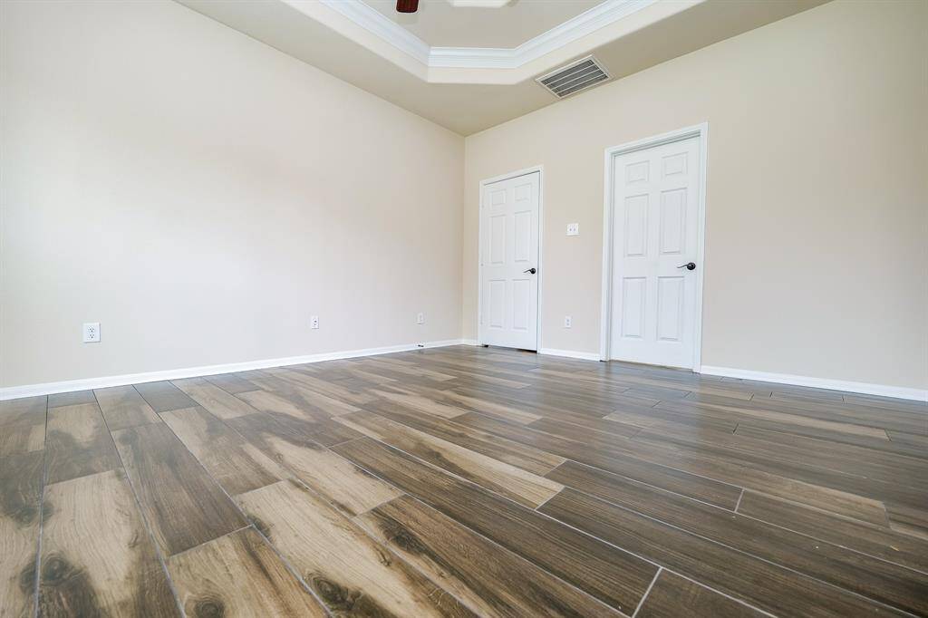 Incredible wall and floor space is embraced by the intimacy of a tray ceiling in the primary suite.