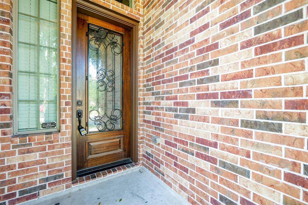 Colorful brickwork lines the welcoming covered front entrance.