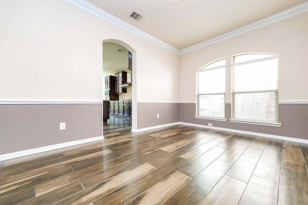 Sublime, light desert tones grace this formal dining room, with its huge double arched windows and arched entry into the kitchen, left.