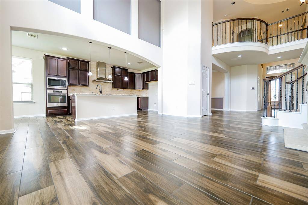 This view defines symmetry in a grand, yet warm presentation in this complete look from living and combined kitchen areas, up to the Juliet balcony-like railing, with a clear view, right, straight to the front door!