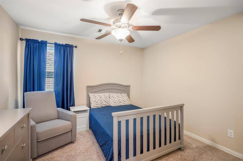Carpeted Secondary Bedroom with crown molding and a ceiling fan