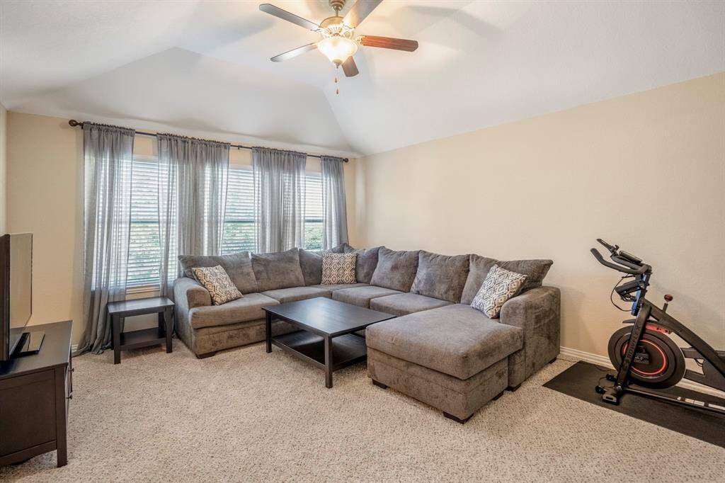 Upstairs Gameroom/Flex Space with carpet, a vaulted ceiling and a fan