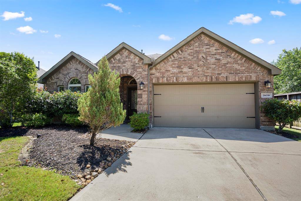 This double-wide driveway leads to a two-car Garage and brick surround.