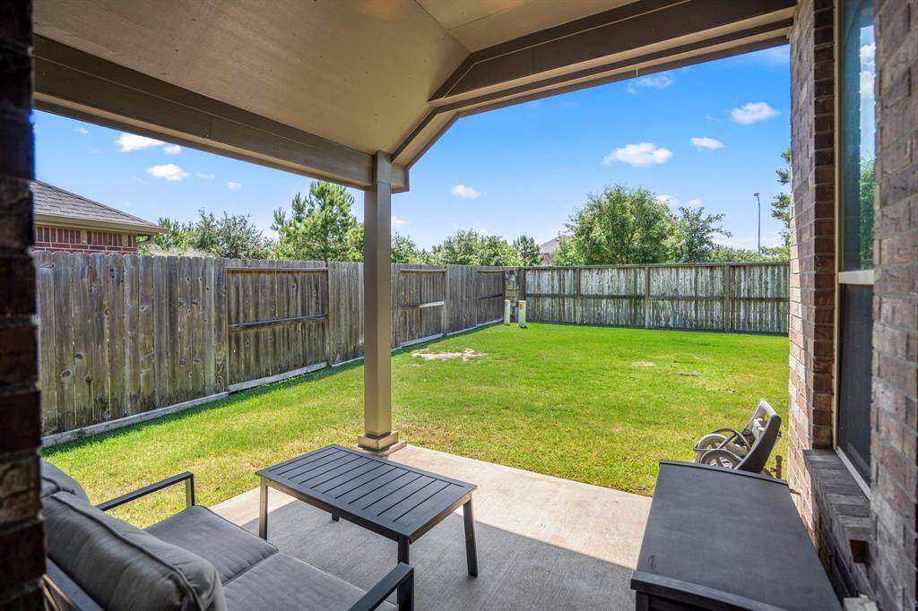 View of the backyard from the covered Patio.  No back neighbors in this home!