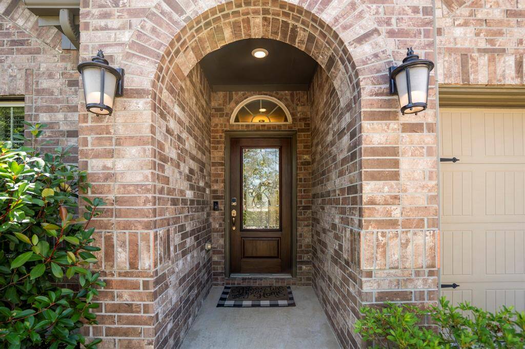 Covered, brick walkway to the leaded, solid wood front door