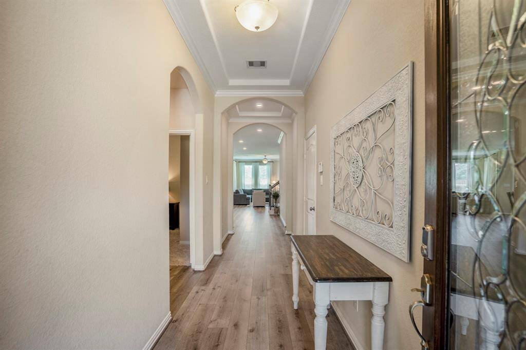 The front hall is light and bright with architectural details on the ceiling