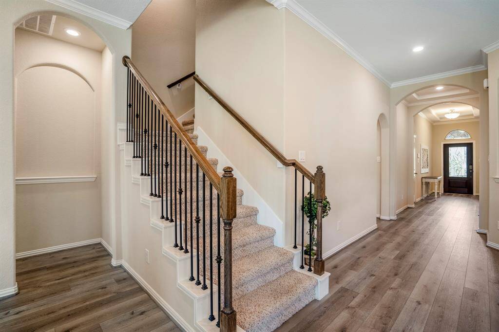 Carpeted staircase with iron details in the front hall.  The stairs lead to the upstairs gameroom.