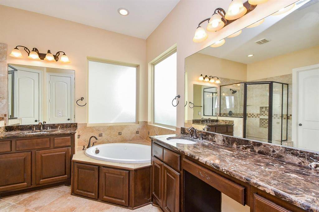 This Study room features warm beige walls, rich hardwood flooring, and a ceiling fan with lights. It includes a window with blinds for natural light and a double-door closet, offering a cozy and functional space.