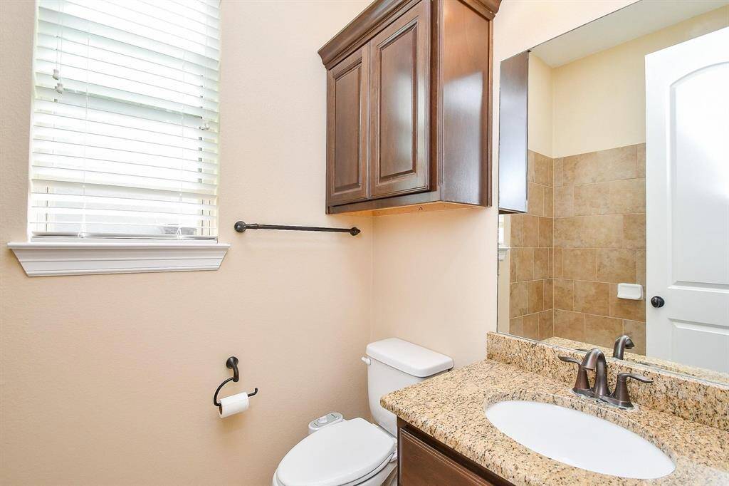 This spacious bathroom features a luxurious soaking tub, a glass-enclosed shower with tile accents, dual sinks with elegant dark countertops, and ample natural light.