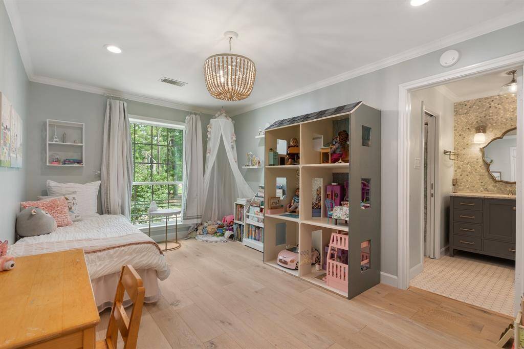 The next secondary bedroom upstairs with a large window and you can see the vanity area of the Hollywood bath serving this bedroom.  There is also a walk in closet.