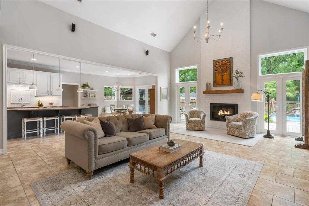 The open floor plan allows mingling between the rooms and for all to enjoy the views to the back gardens with a pool and the cozy fireplace!