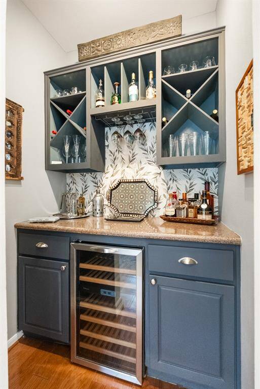 The bar area is conveniently located and includes a wine fridge, storage and serving counter.