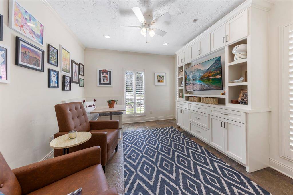 Off the kitchen is a versatile flex space with a custom entertainment center—ideal for a playroom, homework area, TV room, or additional office.