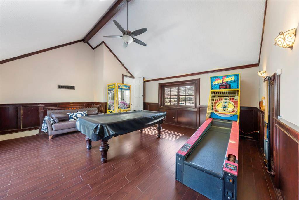 Spacious game room with a vaulted ceiling, plenty of windows for natural light, and ample space for entertainment. The arcade games and pool table are included, if desired.