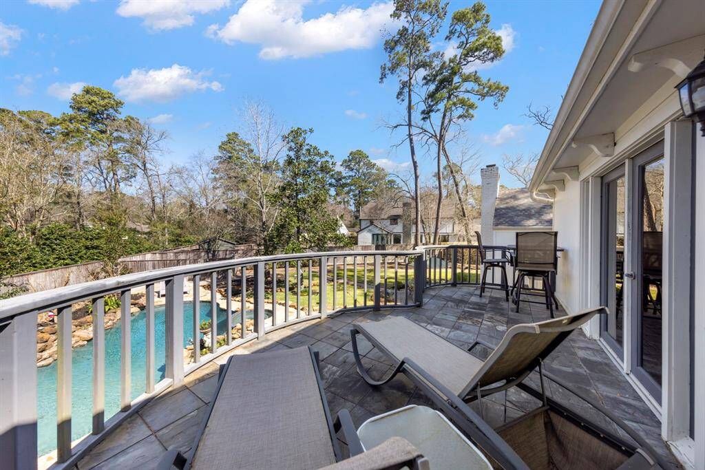 The balcony off the game room offers stunning views of the expansive, lush backyard—perfect for relaxing and enjoying the serene surroundings.