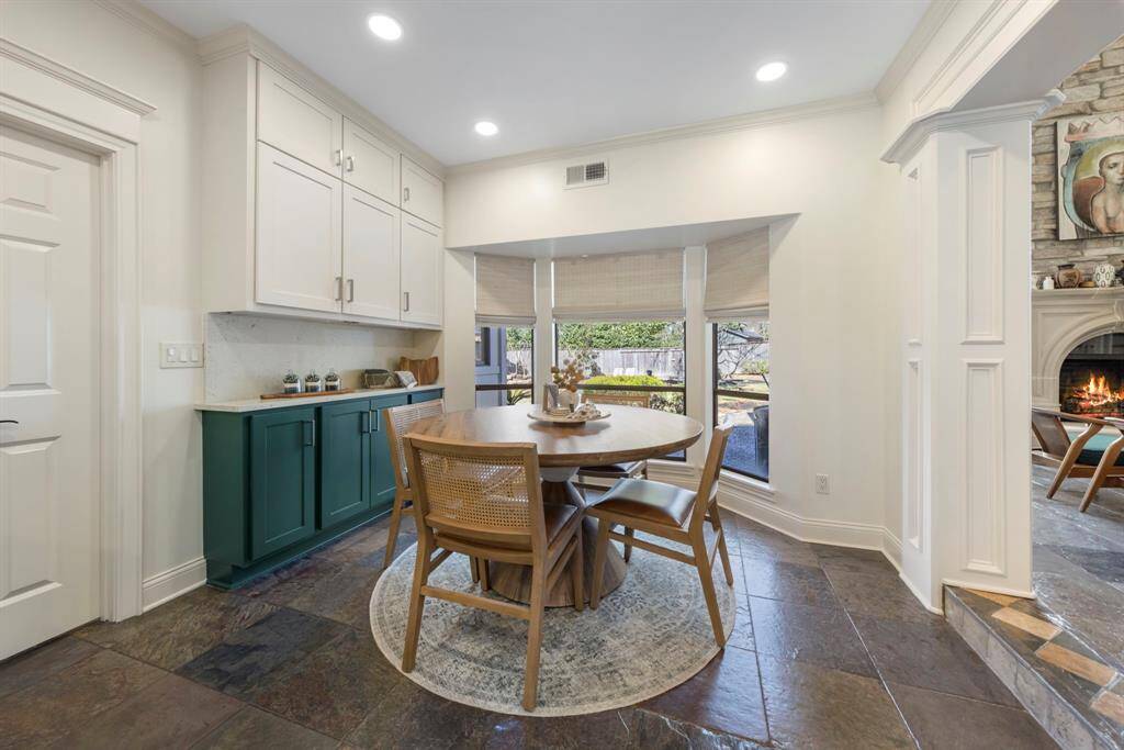 Adjacent to the kitchen is a charming breakfast nook with bay windows and extra cabinetry for added storage.