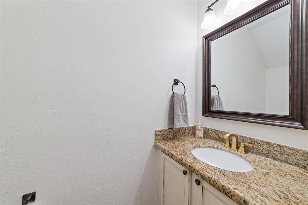 1/2 bath with granite countertop located off the second living room.