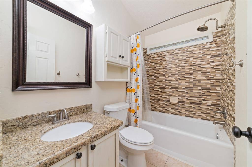 Secondary bathroom with granite countertop.