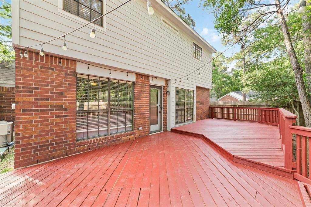 Large 2-tier refinished deck extending from side-to-side (measuring 33x12) with railing and built-in bench.