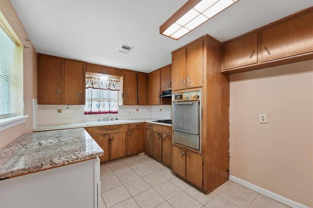 The kitchen offers plenty of space and possibilities for future buyers to create their own vision.