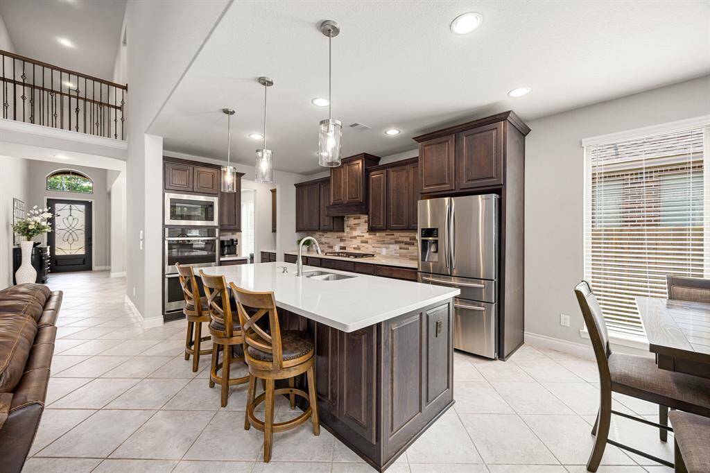 Chef-Style Kitchen With Quartz Counters, Stainless Appliances, Double Ovens, Gas Cooktop & Center Island With Breakfast Bar.