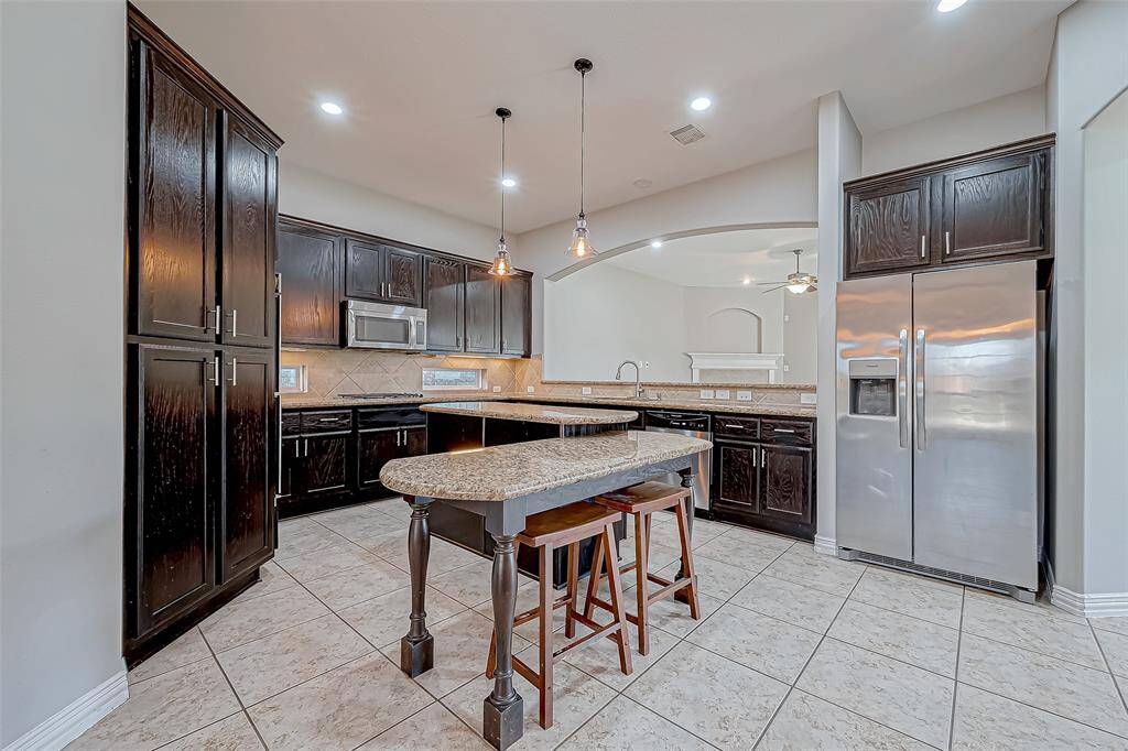 Experience a beautifully designed kitchen with rich dark cabinets and a sophisticated countertop ideal for creating memorable meals and gatherings with your family and guests!