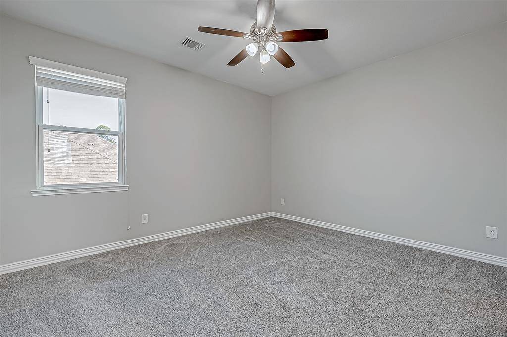 Step into this delightful bedroom with soft carpet and a ceiling fan, one of four cozy retreats waiting for you.