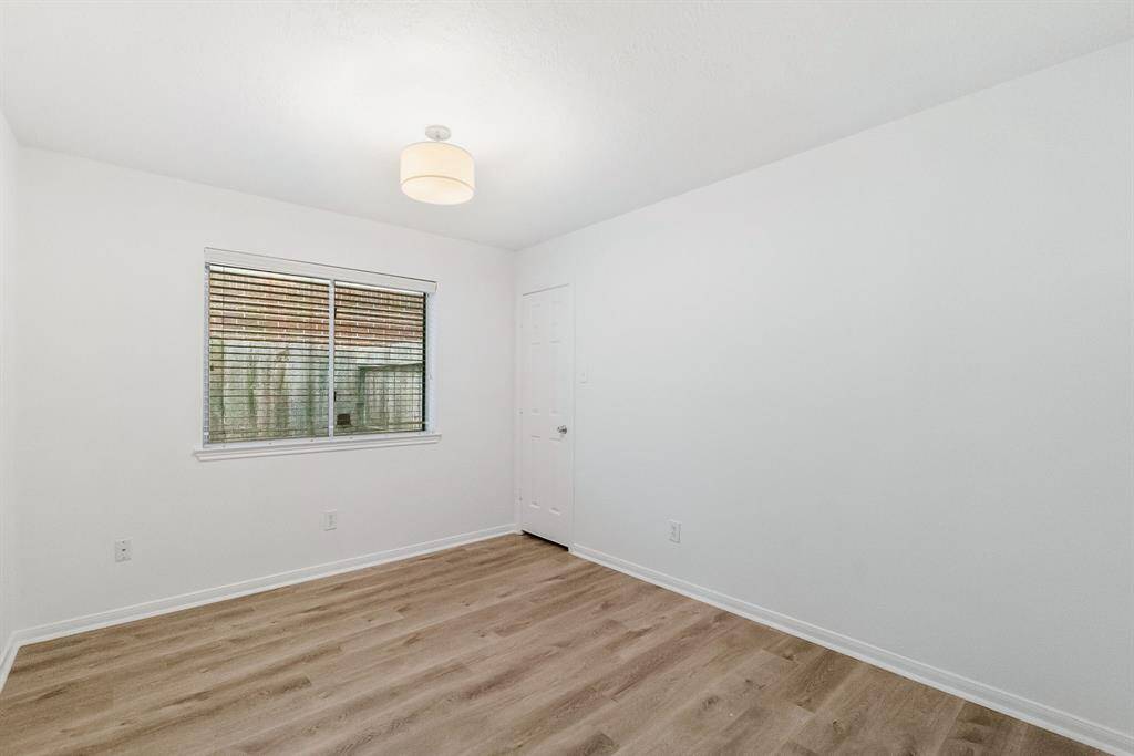 Secondary bedroom with vinyl plank flooring and closet.