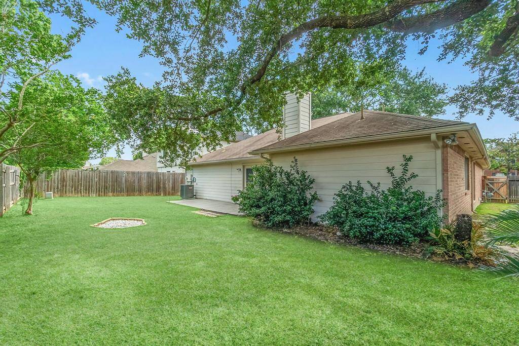 Huge backyard with fire pit, provides privacy with full deck and automatic sprinkler system