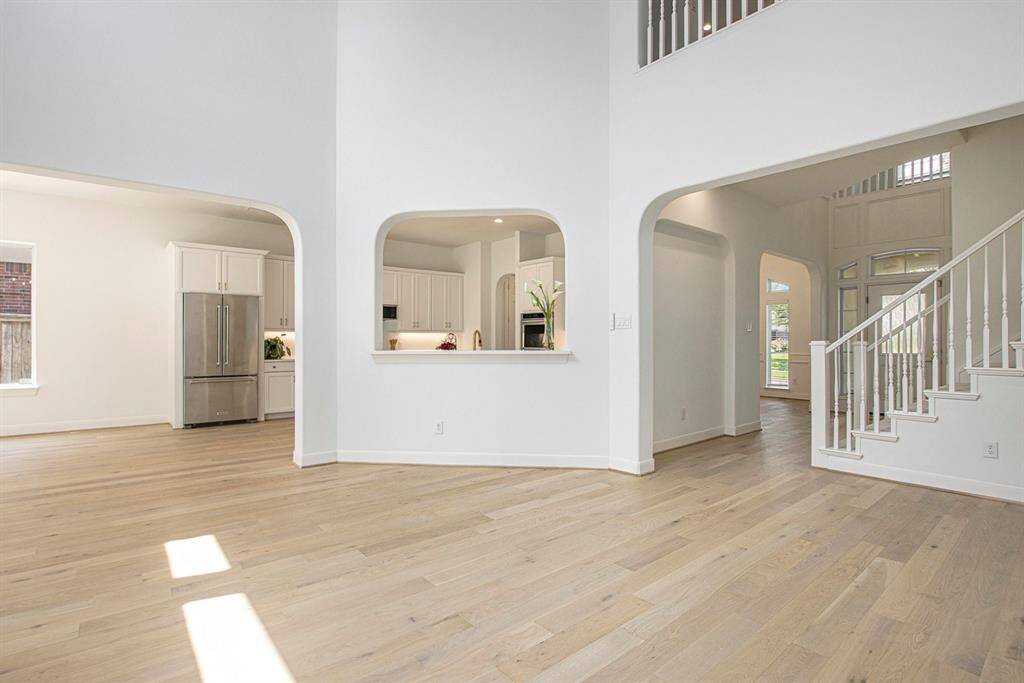 A reverse shot of the living room from the fireplace shows again the high ceilings and multiple arch ways.