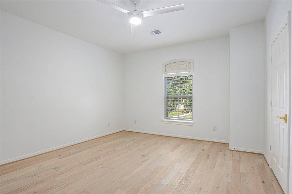 Heading upstairs, this is a bright, spacious room with light wood floors, and a stylish ceiling fan.