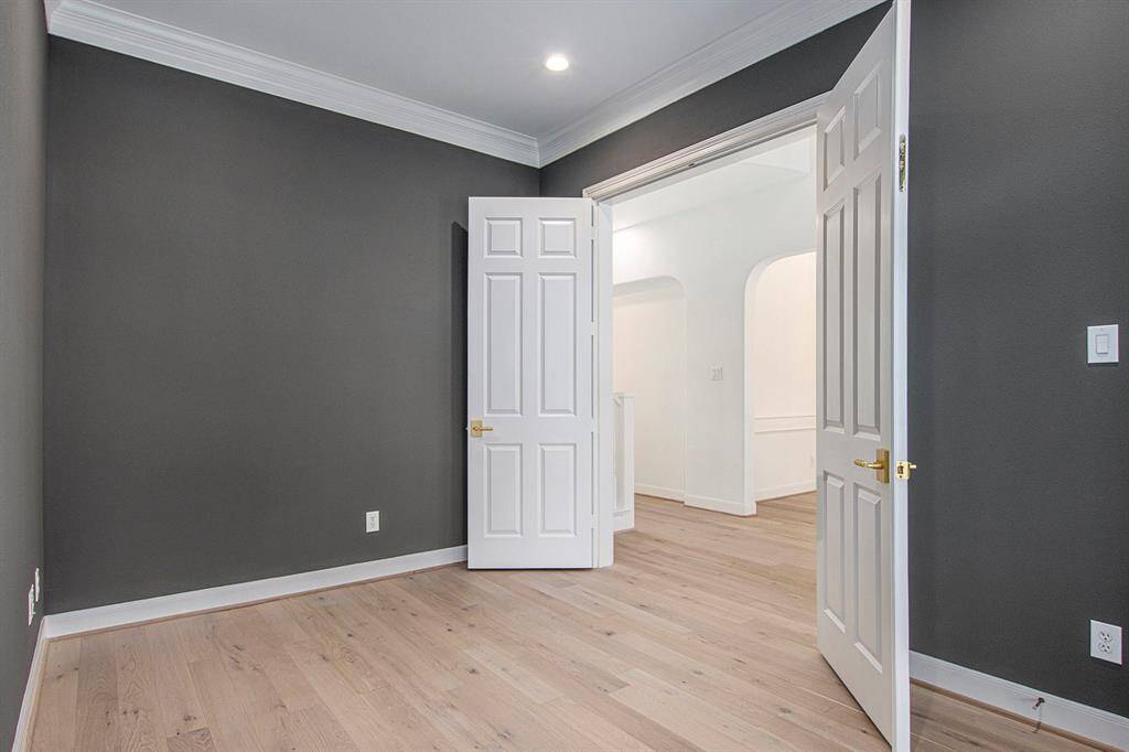 A reverse angle of the study shows the white double doors with gold handles, offering a modern and elegant look.
