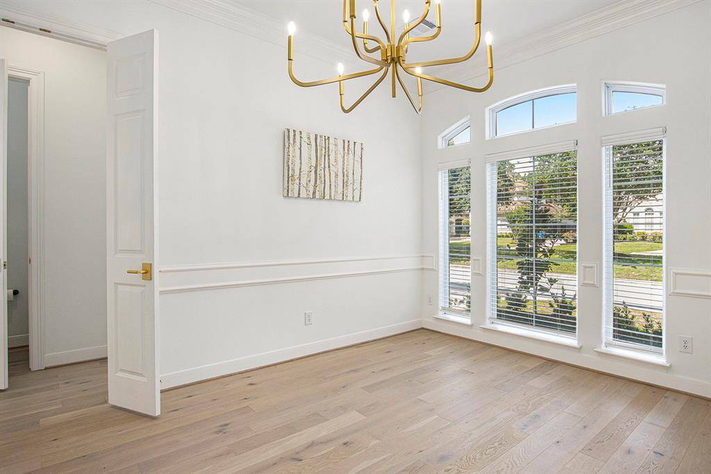 Welcome to the formal dining room, again with large windows, an elegant light fixture, and wood floors.