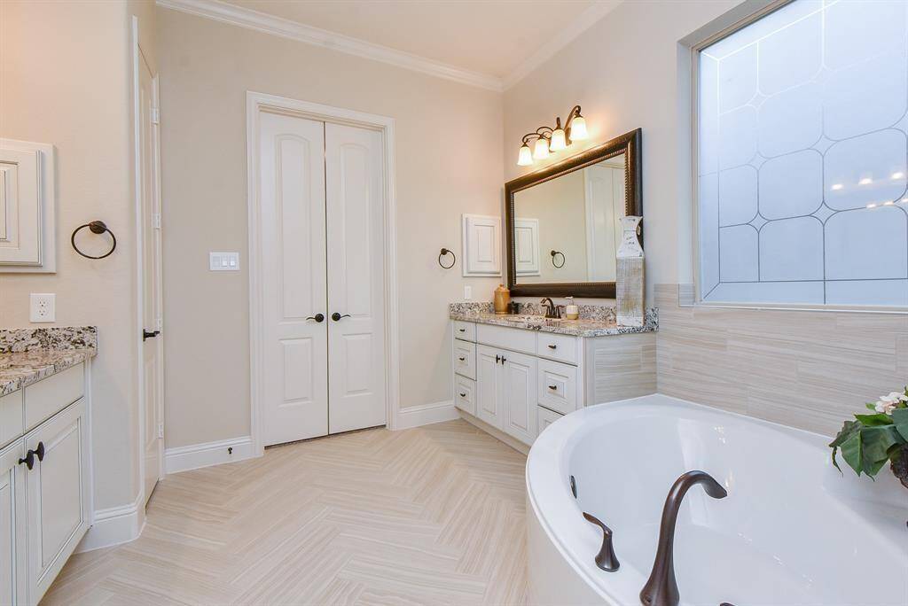 Primary bath features two vanities, large tub, and walk-in shower