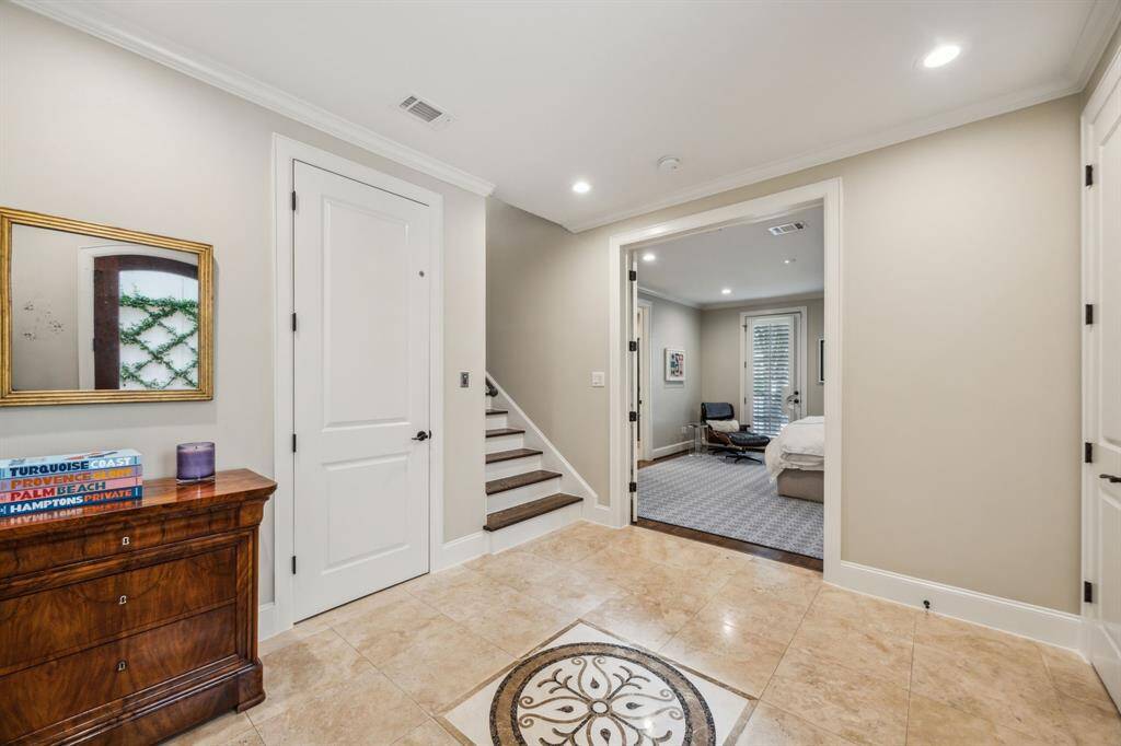 Spacious 12’5” x 10’9” entry showcases elegant Travertine flooring with a striking ornate medallion centerpiece. Features include a convenient hall closet, crown molding and direct access to the attached two-car garage.