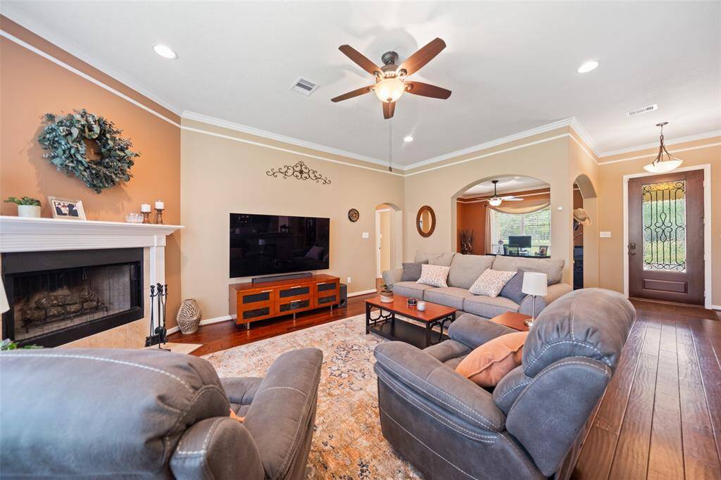 Spacious living area anchored by a cozy fireplace and large windows, offering a warm and inviting spot for gatherings or everyday living.