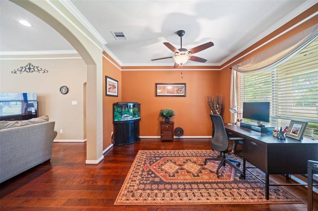 Dedicated office with vibrant accent walls and a large picture window—perfect for working from home with a peaceful view.