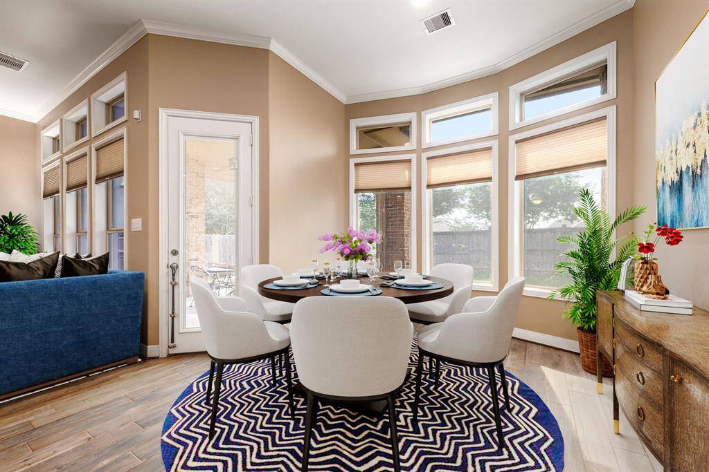 This lovely breakfast area is perfect for starting the day out on the right foot. This space showcases custom paint, recessed lighting, large windows adding to the ample natural light in the kitchen and wood like flooring. *virtual staging*
