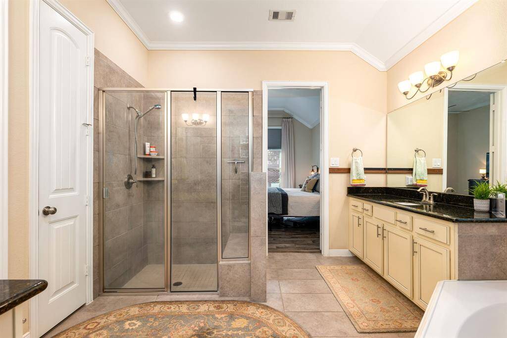 This additional view of the primary bath showcases a walk-in shower with tile surround.