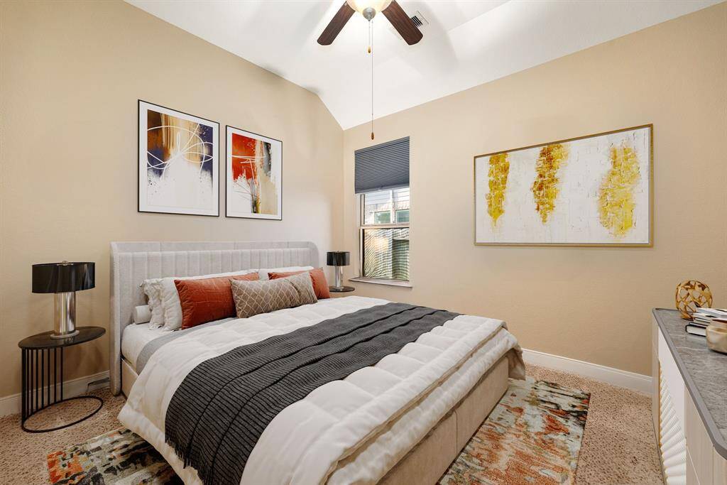 Secondary bedroom features plush carpet, custom paint, dark stained ceiling fan with lighting and a large window with privacy blinds. *virtual staging*