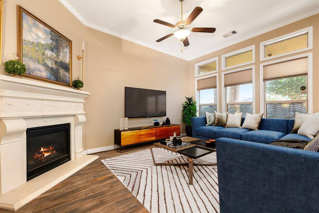This living room is more like a GREAT room featuring a stunning fireplace with mantel detailing, custom paint, dark stained ceiling fan and an amazing wall of windows providing a lovely view of your backyard to keep an eye out on the kids or pets playing. *virtual staging*