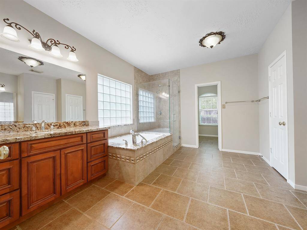 En suite bath with soaking tub and walk in glass enclosure/tile shower.